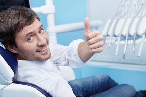 Man happy at the dentist's office thanks to plaque removal and care